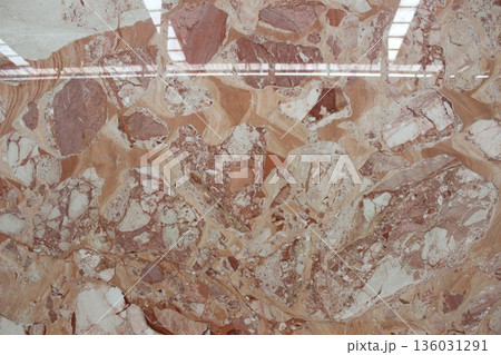 The shiny surface of Breccia Rosso marble featuring unique and luxurious reddish clastic rock fragments. The shiny surface of Breccia Rosso marble featuring unique and luxurious reddish clastic rock fragments. 136031291