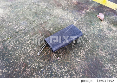 lost black glitter clutch purse with silver chain and rhinestone detail abandoned on a wet concrete ground next to a yellow painted curb lost black glitter clutch purse with silver chain and rhinestone detail abandoned on a wet concrete ground next to a yellow painted curb 136031452
