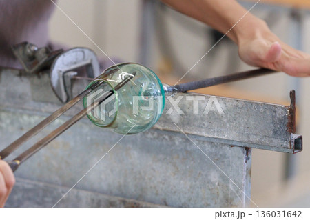 吹きガラス制作中にガラスコップを成形する工程 136031642