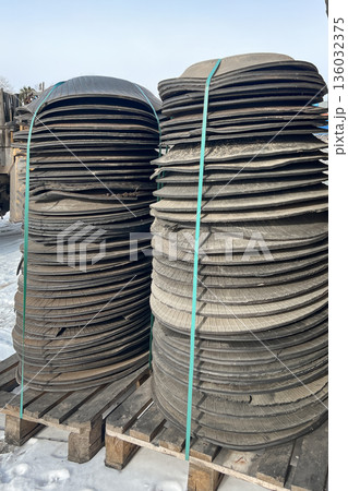 The raw material for recycling is rubber in the form of circles. The cut-out parts of the tires are in stacks. hdpe waste is low-pressure polythylene. High quality photo The raw material for recycling is rubber in the form of circles. The cut-out parts of the tires are in stacks. hdpe waste is low-pressure polythylene. High quality photo 136032375