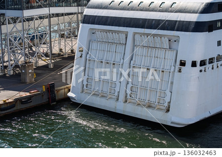 Ferry Docked at Terminal with Open Vehicle Loading Doors. Maritime Transport at Port Arrival Ferry Docked at Terminal with Open Vehicle Loading Doors. Maritime Transport at Port Arrival 136032463