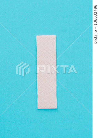 Single chewing gum stick on turquoise background, minimal concept 136032496