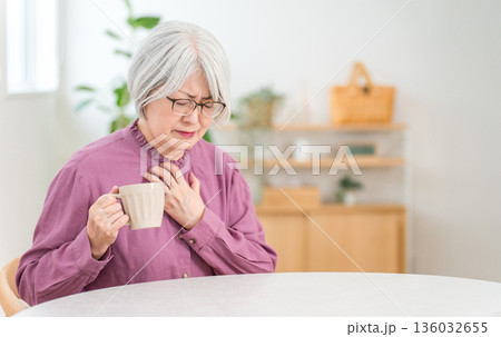 胸痛で苦しくて胸を抑えるシニア女性(誤嚥,むせる,嚥下機能) 胸痛で苦しくて胸を抑えるシニア女性(誤嚥,むせる,嚥下機能) 136032655