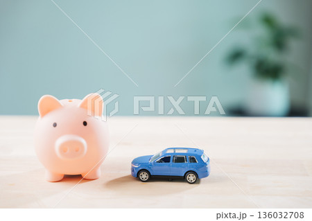 Pink piggy bank near blue toy car for auto finance, insurance, money loan helps saving cost, credit refinance drive away with vehicle budget to save on wooden table background Pink piggy bank near blue toy car for auto finance, insurance, money loan helps saving cost, credit refinance drive away with vehicle budget to save on wooden table background 136032708