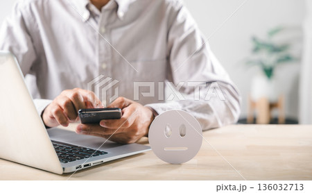 Survey captures neutral customer feedback, man uses smartphone and laptop, diligently evaluates service quality, digital icon reflects overall user satisfaction for brand experience 136032713