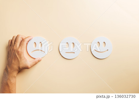 Negative customer feedback choice, male hand selecting unhappy face emoji, indicating poor service review, bad business experience, low satisfaction, user survey rating selection 136032730