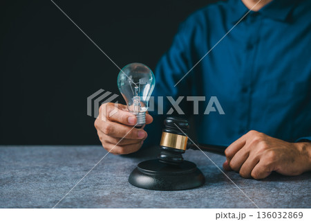 Legal expert holding light bulb near gavel to protect patent intellectual property law, business idea concept protection ensures rights for creative innovation in modern office Legal expert holding light bulb near gavel to protect patent intellectual property law, business idea concept protection ensures rights for creative innovation in modern office 136032869