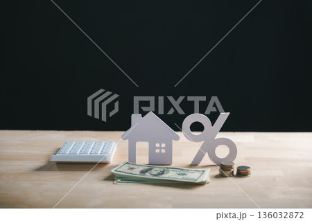 House model, percent sign, money, coins and calculator show home property financing, mortgage loan interest rate calculation, real estate investment 136032872