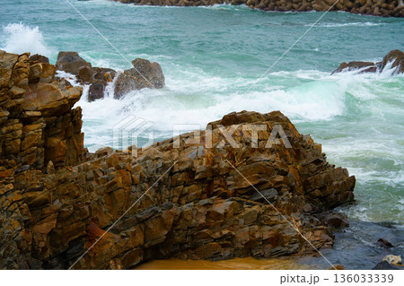 Waves of the East Sea crash against the breakwater and rocky shore, South Korea 136033339