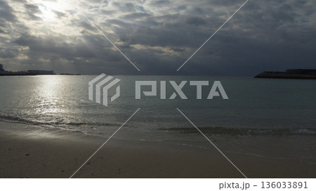 曇り空の夕方、宜野湾トロピカルビーチの静かな海 曇り空の夕方、宜野湾トロピカルビーチの静かな海 136033891