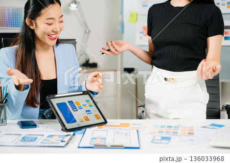 Two UX UI designers brainstorming mobile app wireframes in a modern startup office, showcasing creative teamwork, digital design Two UX UI designers brainstorming mobile app wireframes in a modern startup office, showcasing creative teamwork, digital design 136033968