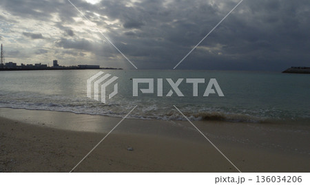 曇り空の夕方、宜野湾トロピカルビーチの静かな海 136034206
