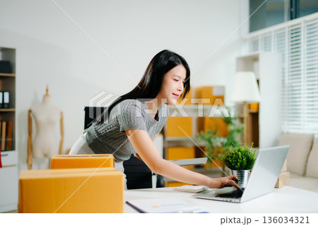 Startup small business SME, Entrepreneur owner woman using smartphone or tablet taking receive and checking online purchase shopping order Startup small business SME, Entrepreneur owner woman using smartphone or tablet taking receive and checking online purchase shopping order 136034321