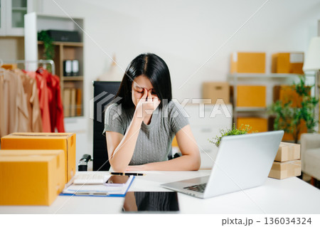 Stressed woman entrepreneur feeling burnout while managing ecommerce orders at home office. Business pressure, startup problems 136034324
