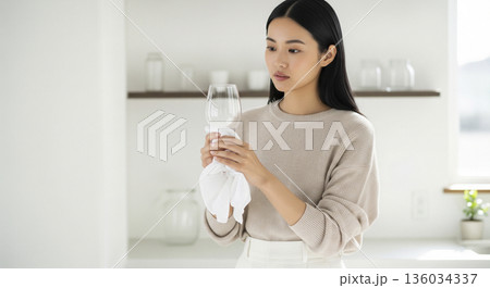 キッチンでワイングラスを磨きながら考え事をする日本人女性 136034337