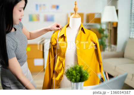 Fashion designer presenting apparel on mannequin with color palette in a studio. Creative styling process, garment development, textile planning 136034387