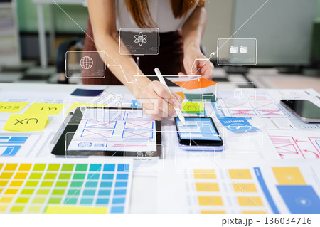 Close up view of UI developer team brainstorming on their project with laptop, smartphone and digital tablet. Close up view of UI developer team brainstorming on their project with laptop, smartphone and digital tablet. 136034716