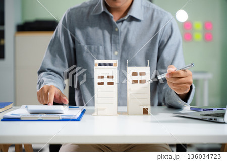 Real estate broker agent presenting and consult to customer to decision making sign insurance form agreement, home model, concerning mortgage loan offer 136034723