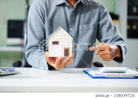 Real estate broker agent presenting and consult to customer to decision making sign insurance form agreement, home model, concerning mortgage loan offer 136034728