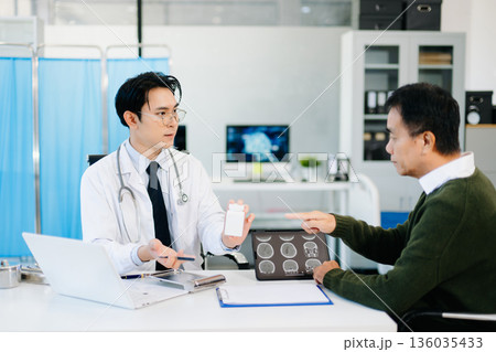Doctor discussing brain MRI results and medication with patient during medical consultation. Perfect for healthcare, diagnosis Doctor discussing brain MRI results and medication with patient during medical consultation. Perfect for healthcare, diagnosis 136035433