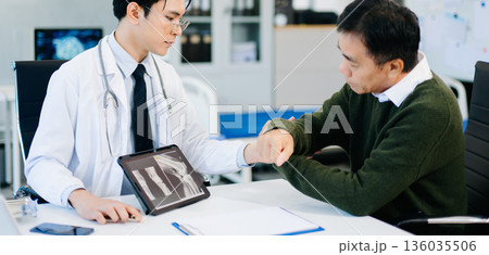 Doctor explaining knee X-ray results to patient in clinic, symbolizing orthopedic diagnosis, treatment, and modern healthcare consultation. Doctor explaining knee X-ray results to patient in clinic, symbolizing orthopedic diagnosis, treatment, and modern healthcare consultation. 136035506