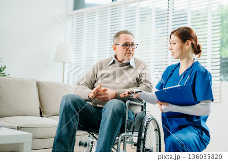 A professional nurse in blue uniform consults with a senior wheelchair patient at home, showcasing real people, empathy, and quality medical care A professional nurse in blue uniform consults with a senior wheelchair patient at home, showcasing real people, empathy, and quality medical care 136035820
