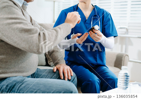 Nurse in blue scrubs reviews medication with an elderly patient at home, showcasing real people, compassionate care Nurse in blue scrubs reviews medication with an elderly patient at home, showcasing real people, compassionate care 136035854