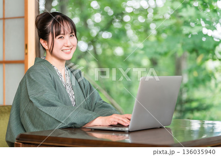 温泉旅館の部屋でパソコンで仕事をする浴衣姿の女性 温泉旅館の部屋でパソコンで仕事をする浴衣姿の女性 136035940