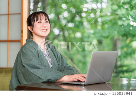 温泉旅館の部屋でパソコンで仕事をする浴衣姿の女性 温泉旅館の部屋でパソコンで仕事をする浴衣姿の女性 136035941