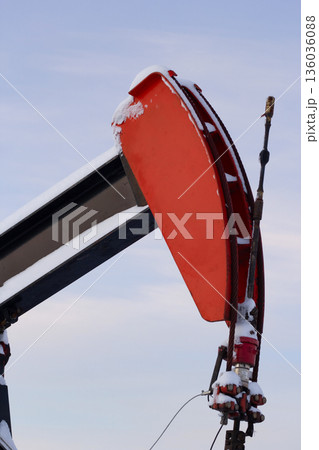 Oil Pumpjack's horsehead against blue and pink sky. 136036088