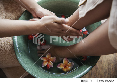 Massage Thai Spa foot massage flower oil therapy. Close up woman foot therapy relax treatment Aromatherapy salon. Spa legs relaxation muscle relief. Woman happy relax skin Foots Soak spa oil wellness 136036282