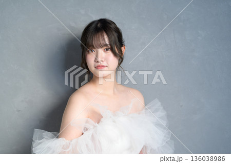 グレー背景でウェディングドレスを着る女性 136038986
