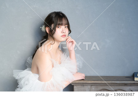 グレー背景でウェディングドレスを着る女性 グレー背景でウェディングドレスを着る女性 136038987