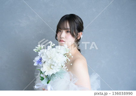 グレー背景でウェディングドレスを着る女性 136038990