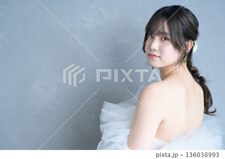 グレー背景でウェディングドレスを着る女性 136038993