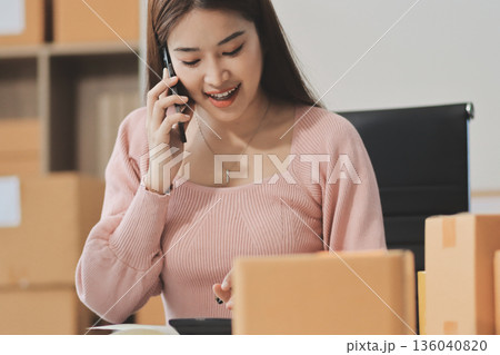 Starting small businesses SME owners female entrepreneurs check online orders to prepare to pack the boxes, sell to customers, sme business ideas online. Starting small businesses SME owners female entrepreneurs check online orders to prepare to pack the boxes, sell to customers, sme business ideas online. 136040820