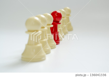 Red pawn stood out from the rest of the pawns representing courage to speak up concept. Red pawn stood out from the rest of the pawns representing courage to speak up concept. 136041336