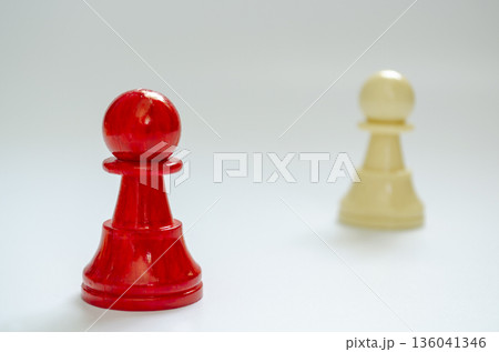 Isolated red pawn with blurred white pawn symbolizing vulnerability and judgment. 136041346