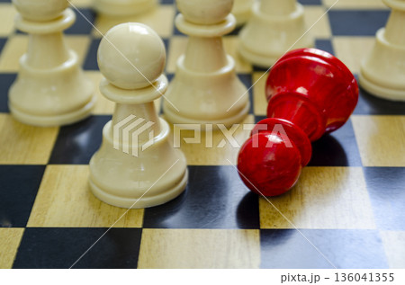 Fallen red pawn among white pawns symbolizing harassment, pressure, and systemic exclusion. Fallen red pawn among white pawns symbolizing harassment, pressure, and systemic exclusion. 136041355