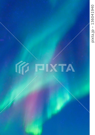 Vertical view of the stunning aurora borealis glowing in a starry night sky. Vertical view of the stunning aurora borealis glowing in a starry night sky. 136041940