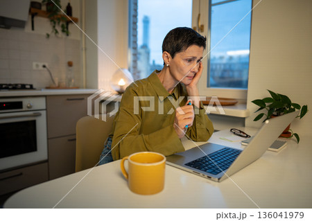 Concentrated stressed senior businesswoman works on remote at home, finishes deadline at late hours. Concentrated stressed senior businesswoman works on remote at home, finishes deadline at late hours. 136041979