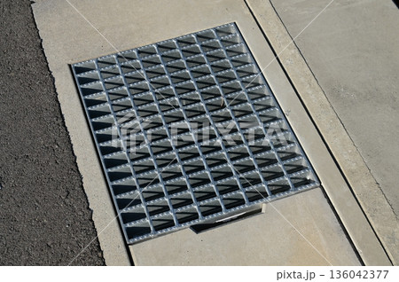 側溝に設置された金属製のグレーチング（みぞ蓋） 136042377