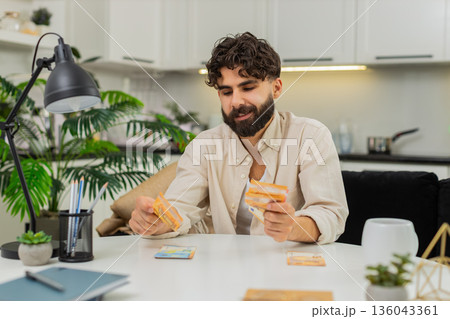 Indian man counting euro cash savings in neat stacks planning budget dreaming about future purchase 136043361