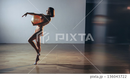 新体操のボールを持つ少女：モダンな体育館での練習風景とコピースペース 136043722