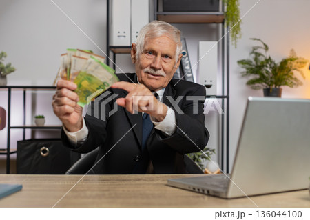 Rich grandfather businessman working on laptop counting money cash, calculate profit at home office 136044100