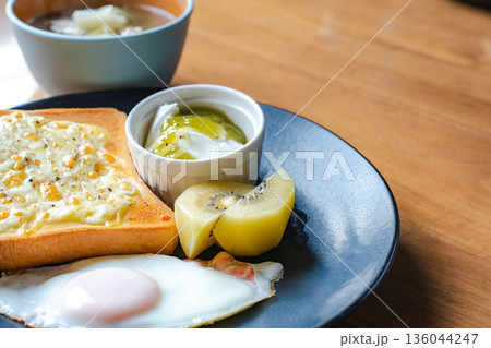 ヨーグルトとゴールドキウイを添えた朝食ワンプレートを木のテーブルに置く 136044247