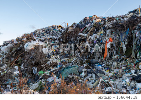 Waste accumulates in towering heaps at a busy landfill, highlighting the urgent need for better waste management and ecological awareness 136044519