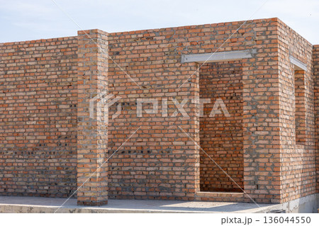 Sunlight bathes the fresh brick walls of a newly built structure, highlighting the intricate patterns and promising future possibilities Sunlight bathes the fresh brick walls of a newly built structure, highlighting the intricate patterns and promising future possibilities 136044550