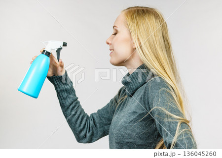 Girl long hair holding spray bottle 136045260