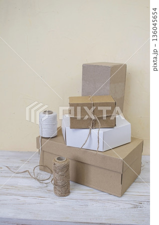 Cardboard boxes and packing twine, delivery concept. Stacking of postal cardboard boxes and packing twine. 136045654